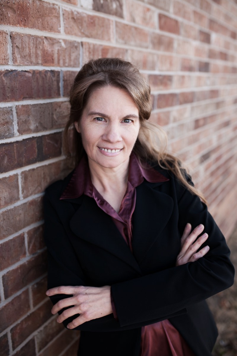 Sherry Taylor, founder of Providential Health, standing against a brick wall.